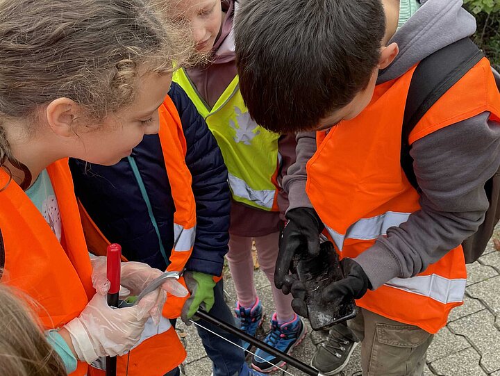 Schülerinnen und Schüler sind fasziniert vom Handy im Müll