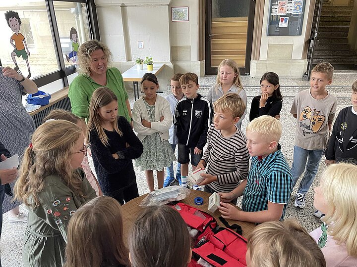 Juniorhelfer der Grundschule im Rot benennen den Inhalt ihres neuen Erste-Hilfe-Rucksacks