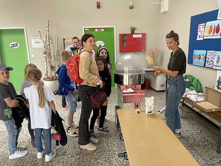 Personen stehen bei der Zuckerwattemaschine an